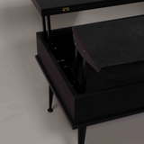 A close-up of a partially open black smart table, showing its internal mechanism, with black metal legs on a white background.