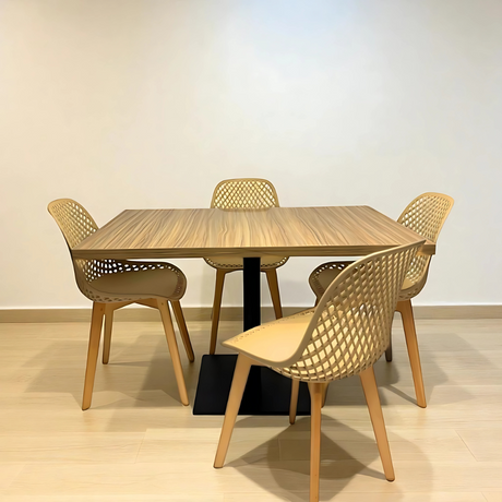 Dining table set with four chairs in a room with a light-colored floor and wall.