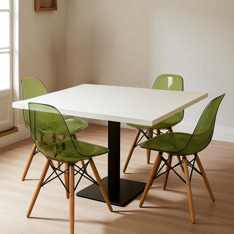 Dining table with four green chairs in a room with light-colored walls and wooden floor.