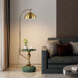 Gold floor lamp with a green base next to a gray sofa in a living room.