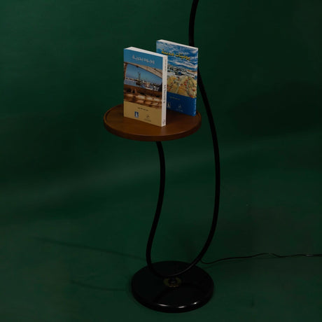  small wooden shelf holding books for a black  floor lamp