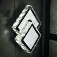diamond-shaped LED wall light with a frosted crystal-like texture, mounted in an dark wall