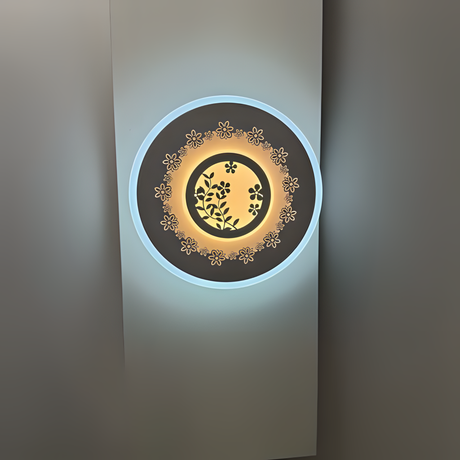 White round wall lamp featuring a small flower motif, mounted on a white wall.