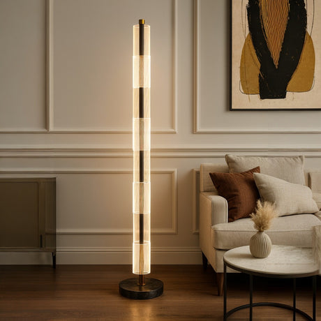 Modern floor lamp in a living room setting with a sofa and abstract art on the wall.