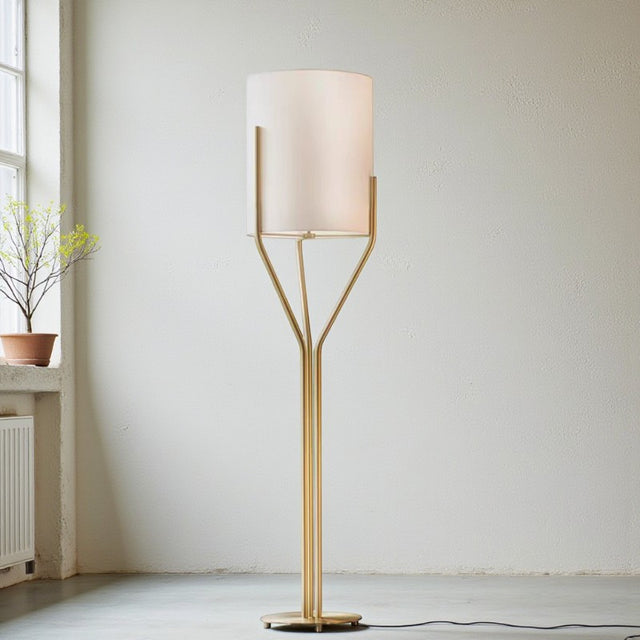 Modern floor lamp with a white shade and gold base in a minimalistic room.
