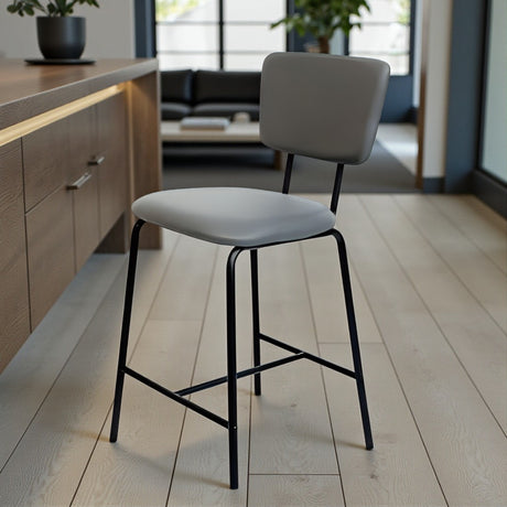 Modern bar stools with grey seats and black legs in a kitchen setting.