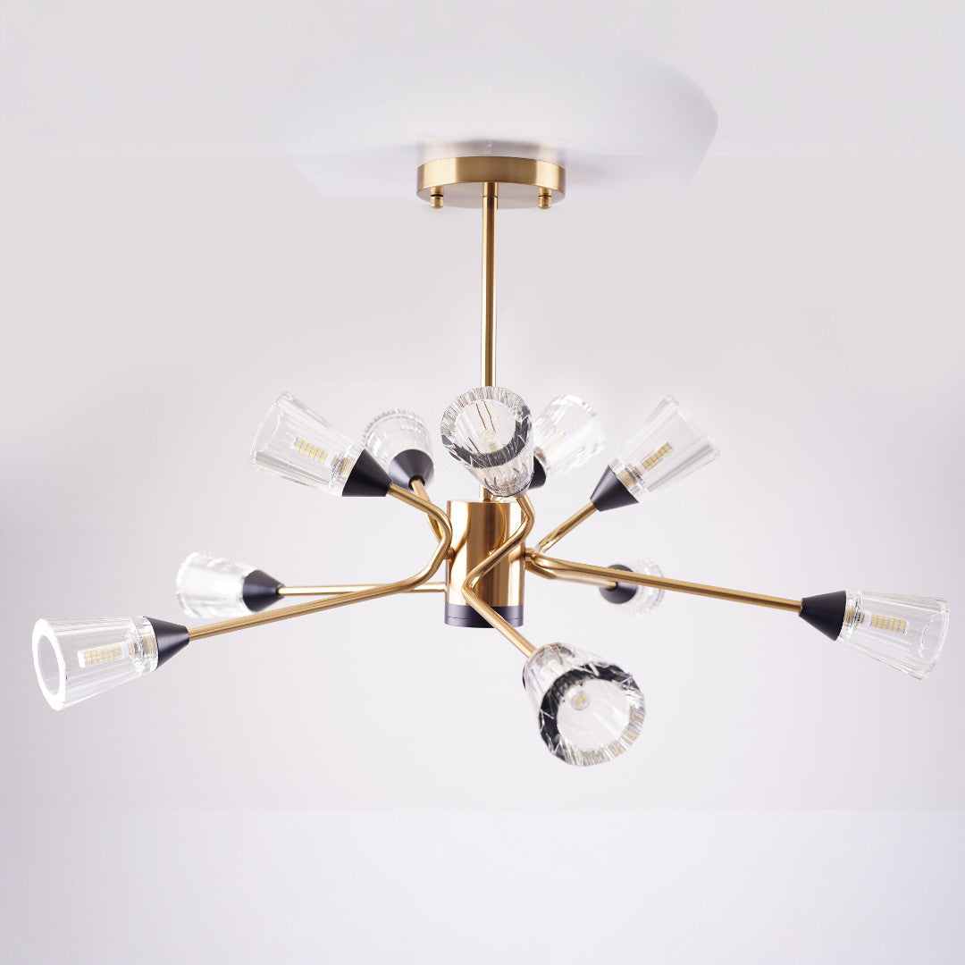 Modern chandelier with gold finish and multiple angled arms holding clear fluted glass shades.
