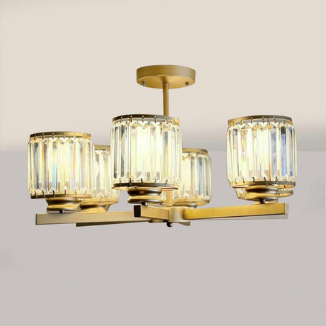  A contemporary ceiling light fixture featuring six cylindrical lamps with clear ribbed glass shades mounted on a gold metal frame against a plain white background.