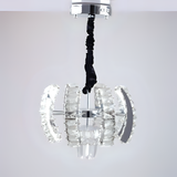 A crystal pendant chandelier with clear textured glass curved panels arranged in a globe formation, unlit, suspended from a black twisted cord and chrome ceiling plate.