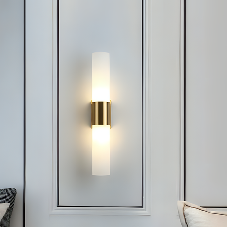 double-cylinder gold and frosted glass wall light, mounted on a white paneled wall.