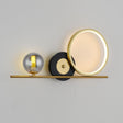 wall light  gold horizontal bar with circular elements, including a frosted LED ring and a smoked glass globe, creating a sophisticated and contemporary look.