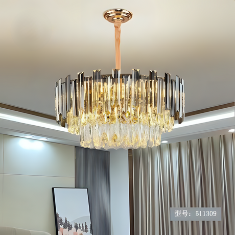 A modern chandelier with gold  accents hanging in a well-lit living room with neutral-colored curtains.