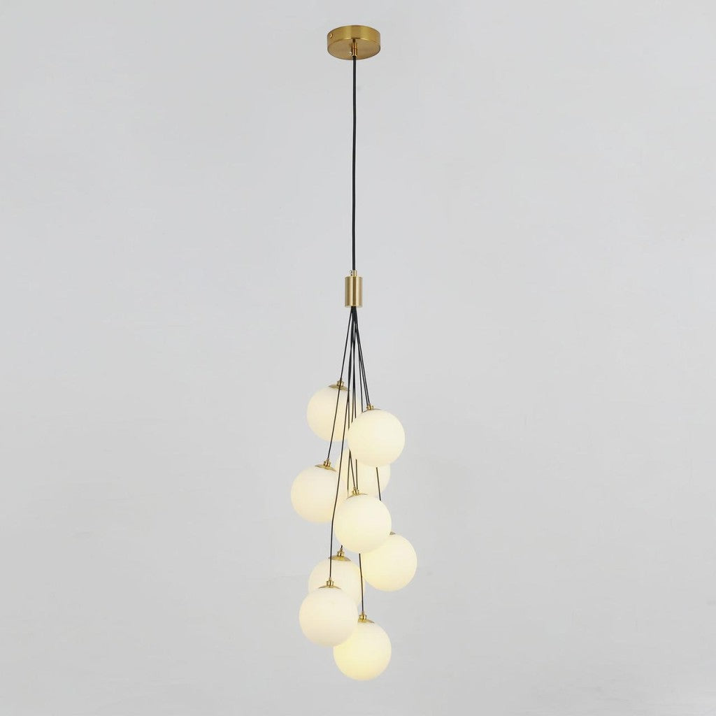  A cluster of frosted white glass globes hanging from a gold fixture, forming a cascading pendant light design.