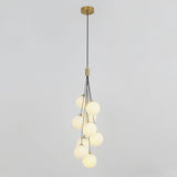  A cluster of frosted white glass globes hanging from a gold fixture, forming a cascading pendant light design.