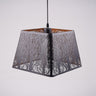 A black square-shaped pendant lampshade with intricate tree patterns cut into the metal frame.
