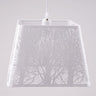A white square-shaped pendant lampshade with intricate tree patterns cut into the metal frame.
