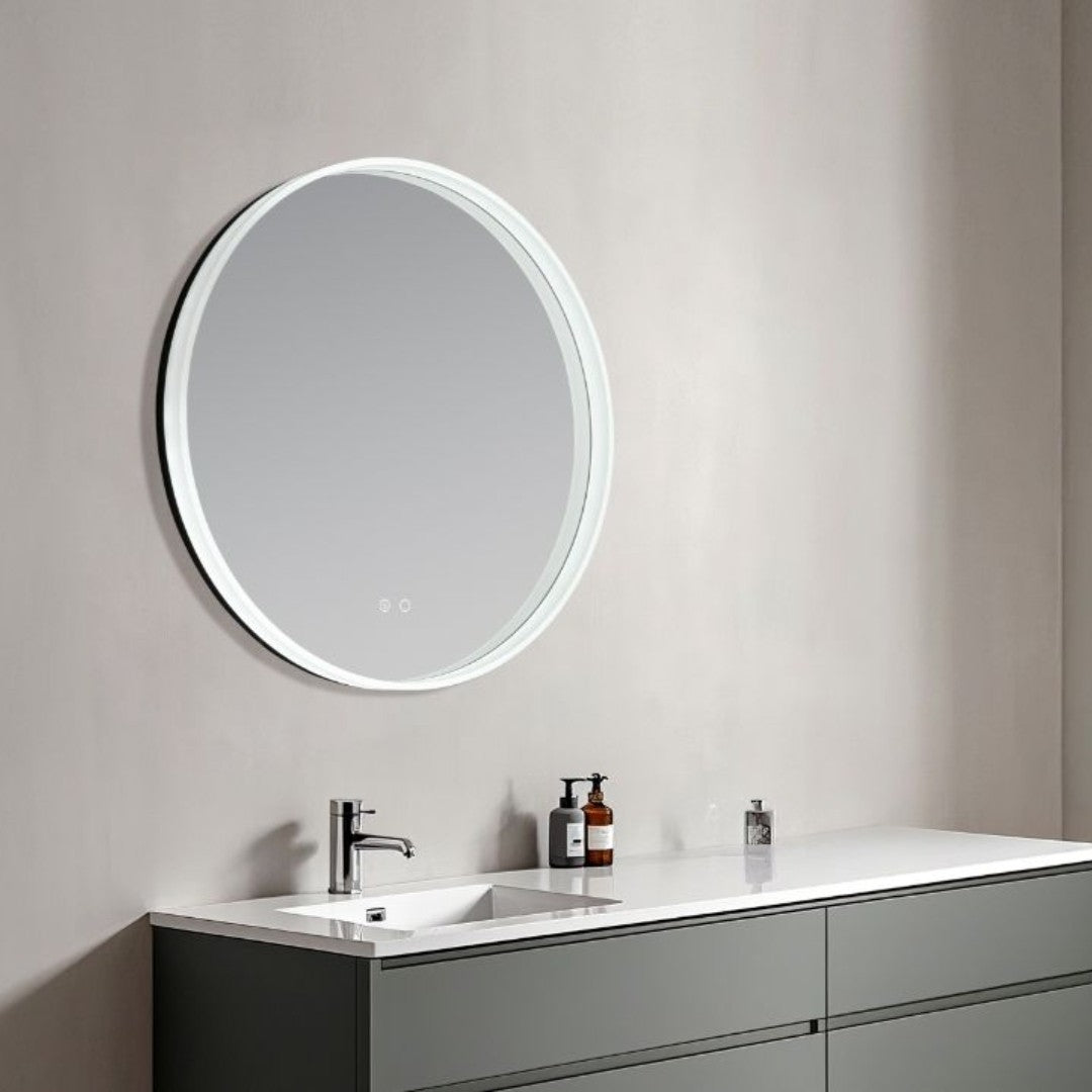 Round illuminated bathroom mirror above a sink with toiletries on a neutral wall.