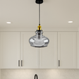 Silver pendant light hanging in a kitchen with white cabinets.
