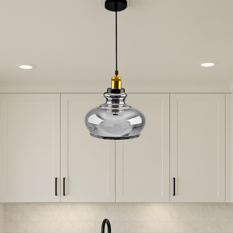 Silver pendant light hanging in a kitchen with white cabinets.