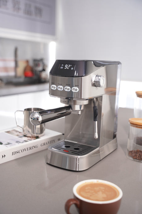 Stainless steel espresso machine on a kitchen counter with a cup of coffee and coffee beans.