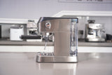 Stainless steel espresso machine on a kitchen counter with blurred background