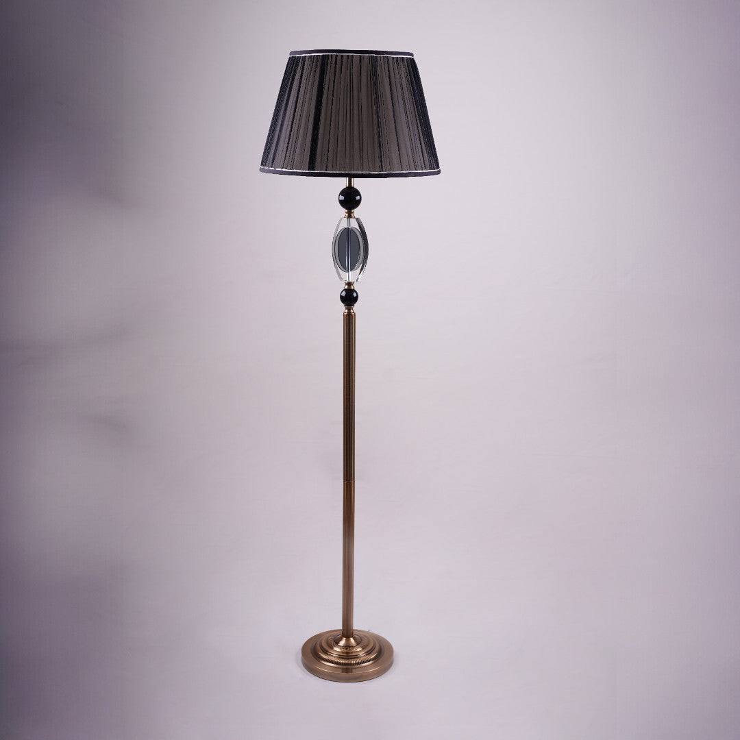 A tall, elegant floor lamp with a black lampshade, a golden stand, and black and crystal accents in the middle.