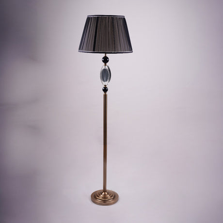 A tall, elegant floor lamp with a black lampshade, a golden stand, and black and crystal accents in the middle.