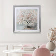 Dining room with pink chairs, a white table, and a framed painting of a cherry blossom tree on the wall.