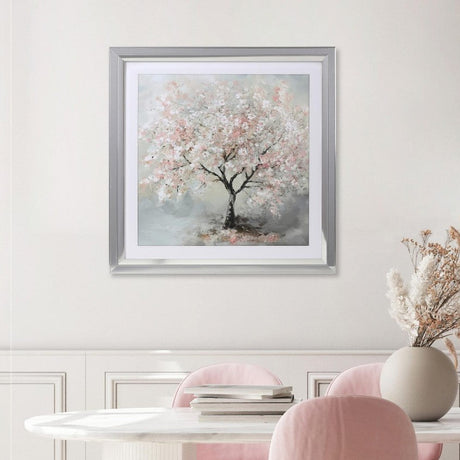 Dining room with pink chairs, a white table, and a framed painting of a cherry blossom tree on the wall.