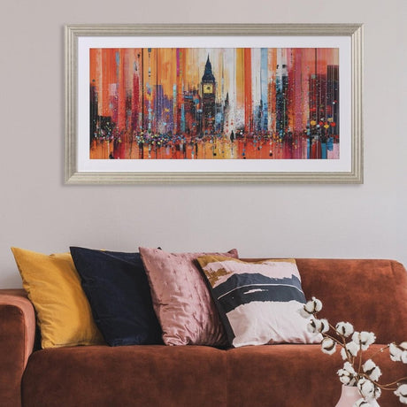 Living room with a brown sofa, colorful pillows, and a cityscape painting on the wall.