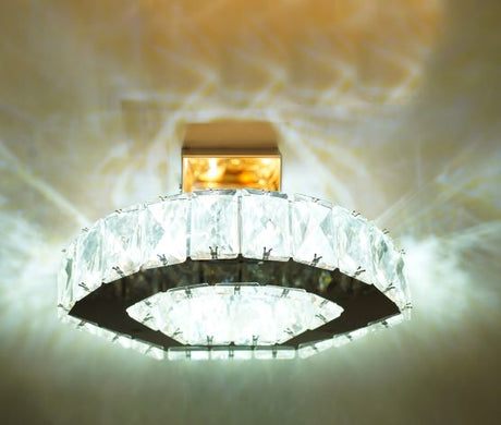 A circular crystal wall light with an elegant ring design, emitting a bright, luxurious glow.	