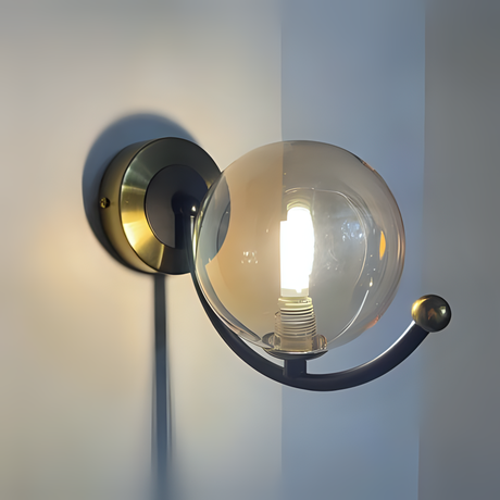 Modern globe-shaped wall light with a transparent glass sphere and black metal arm, featuring a G9 LED bulb and circular wall mount against a neutral-colored wall.