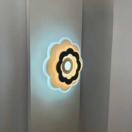 Modern Flower LED Wall Light in a sleek flower shape, crafted from metal and acrylic, fixed on a white wall, emitting soft, warm white light.