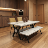 Dining table with marble-like top and black X-shaped legs in a modern kitchen setting.