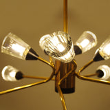 Brushed gold ceiling light with glass bulb holders, arranged in a dynamic starburst pattern, glowing in warm light.