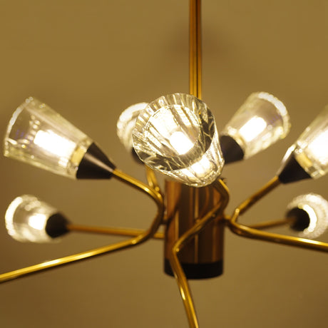 Brushed gold ceiling light with glass bulb holders, arranged in a dynamic starburst pattern, glowing in warm light.