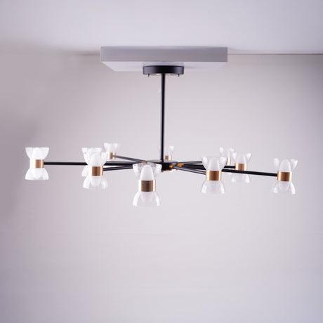 A sleek black chandelier with multiple arms, each holding a small white conical glass shade, mounted on a square ceiling base in a minimalist setting.