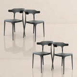  Four dark gray sculpted chairs with artistic backrests, arranged in a square formation on a glossy floor.