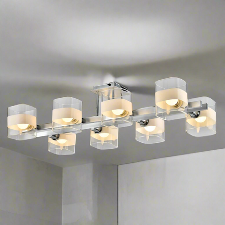  Industrial-style chandelier in brushed metal, with multiple clear and frosted cylindrical glass shades, partially installed with exposed wiring.