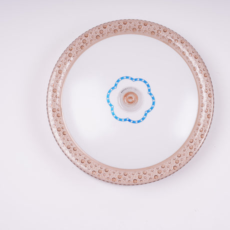 a rose gold circular flush mount ceiling light featuring an ornate ring and a central blue-edged flower motif around the LED. Best for elegant indoor areas like lounges or bedrooms.