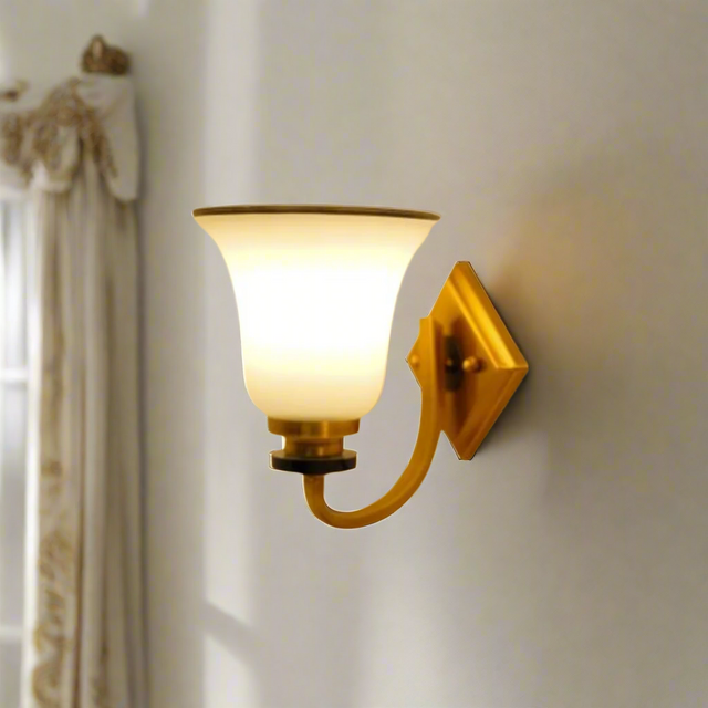 A metal wall sconce with a frosted glass shade, equipped with a led lamp e27 emitting warm illumination placed on a white wall 