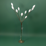 A floor lamp with a metal stand and multiple petal-like white plastic bulbs, arranged like a blooming tree.