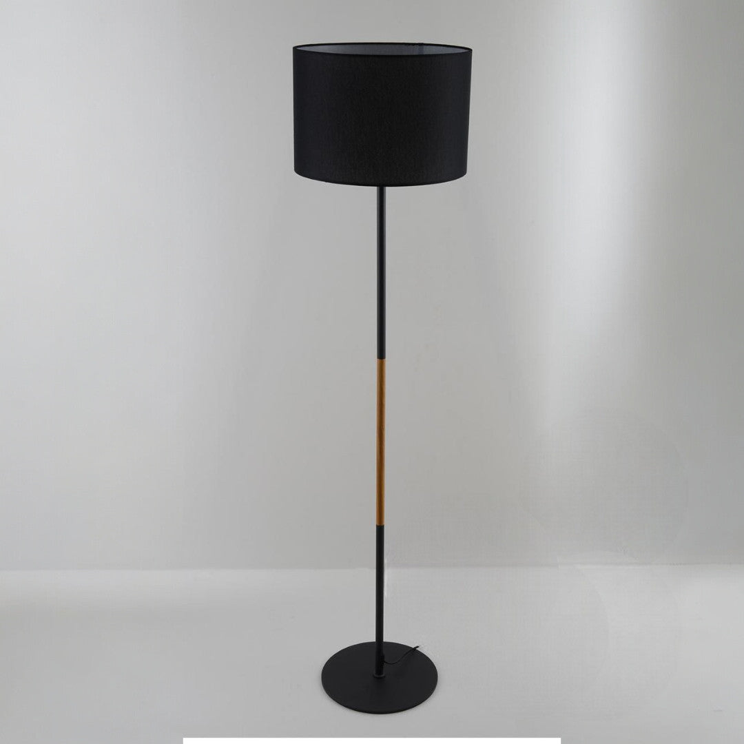 A contemporary black floor lamp with a cylindrical black lampshade and wooden details, set against a plain white background.