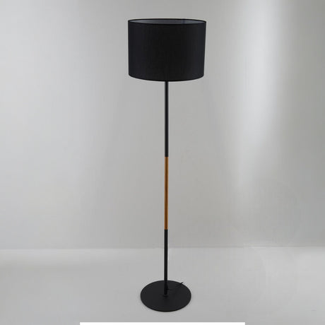 A contemporary black floor lamp with a cylindrical black lampshade and wooden details, set against a plain white background.