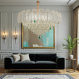 Luxurious living room with a large crystal chandelier, black sofa, and decorative elements.