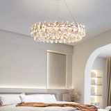 Chandelier hanging in a bedroom with a bed and shelves in the background