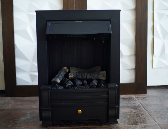  A black freestanding electric fireplace with a closed front, featuring artificial logs inside.