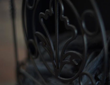 A close-up view of the decorative metal detailing on a black electric fireplace.