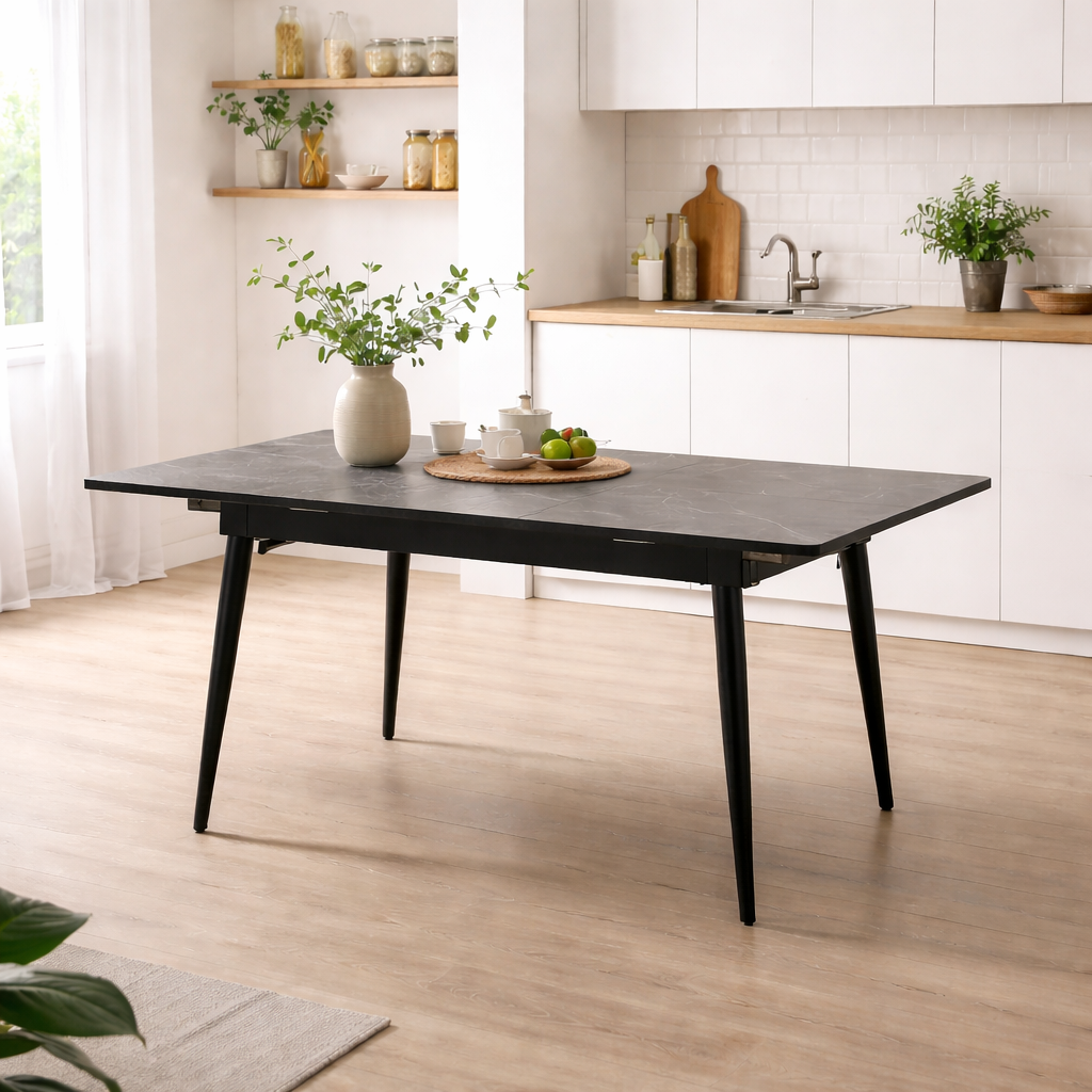 Black dining table in a modern kitchen with white cabinets and wooden flooring.