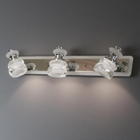 A sleek and contemporary triple-led bulb chrome wall light fixture with clear glass shades, mounted on a metallic base.
